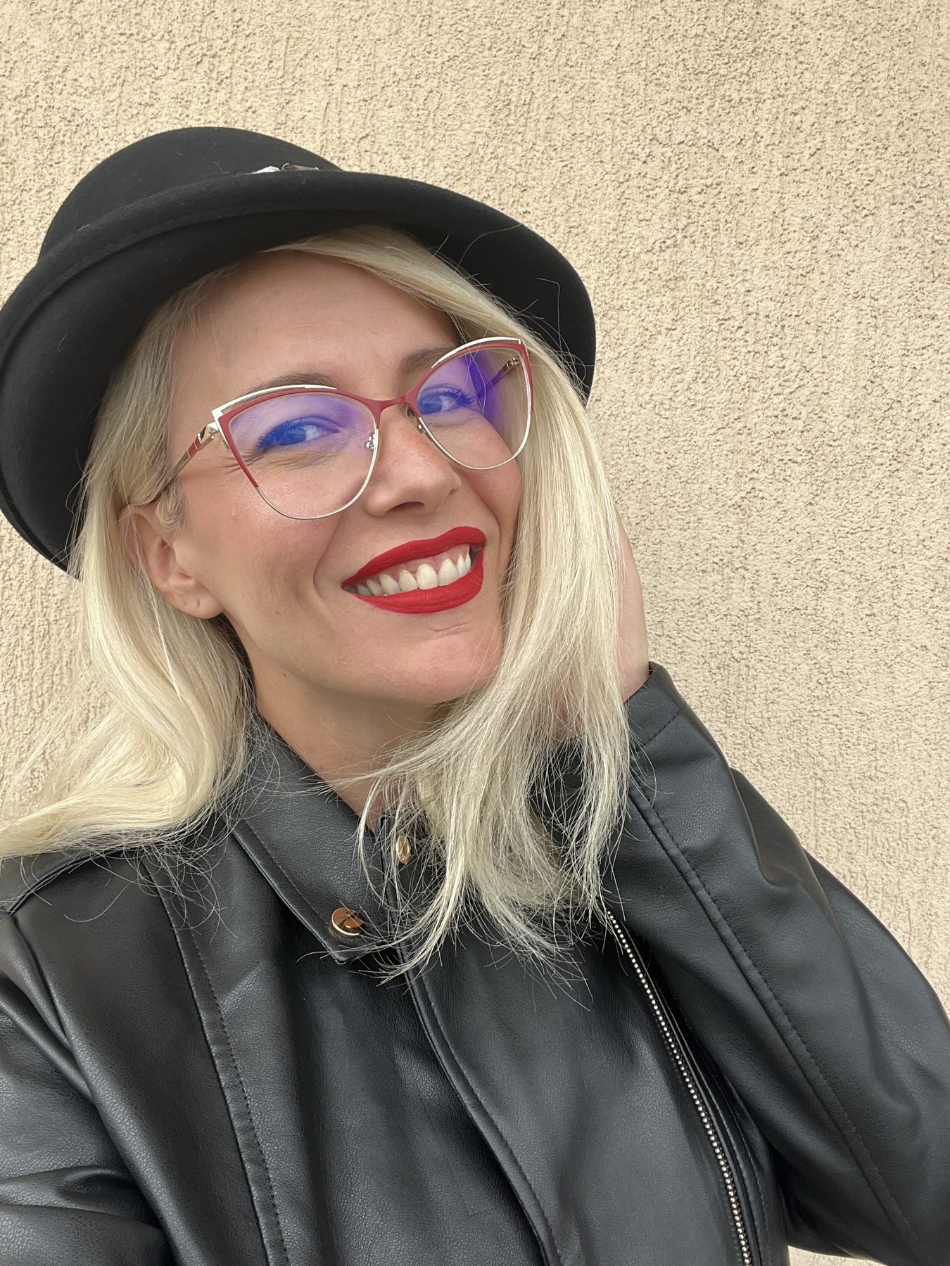 Portret Florentina Baloș, zâmbind, cu pălărie neagră și ochelari