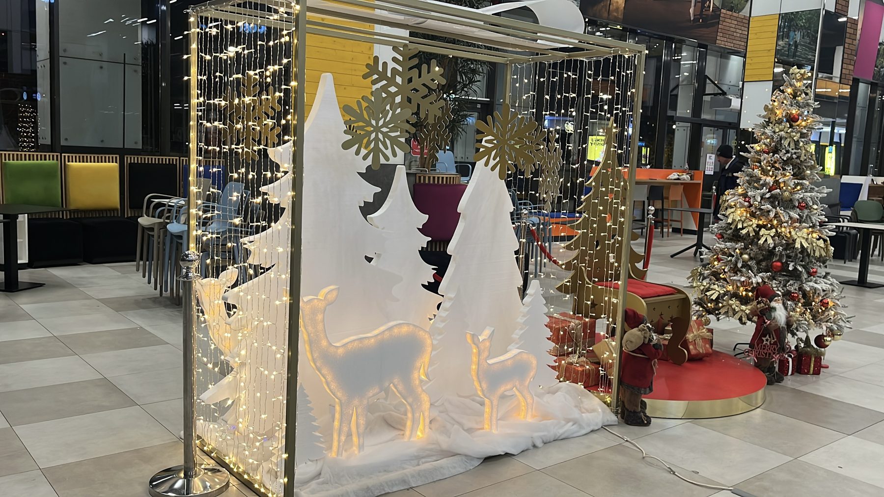 Decor tematic luminos cu brazi albi, căprioare și cortină de lumini